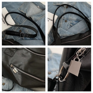 Close-up of black leather tote bag with silver zippers and reinforced stitching details