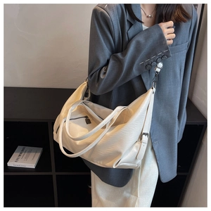 Detailed view of a white large-capacity soft leather tote bag worn by a model