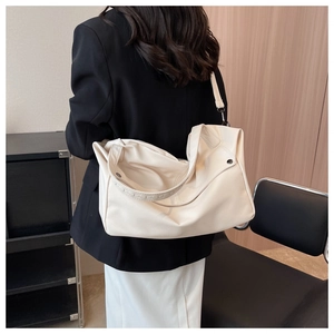 Detail view of cream-white large capacity tote bag with lychee grain texture leather