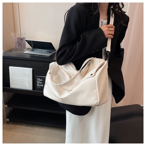 Detail of white litchi pattern leather tote bag shown in a minimalist interior setting