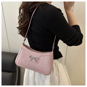 Detail of pink sequin shoulder bag with silver metal bow and quilted lattice texture