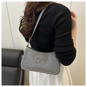 Detail der silbernen Glitzertasche mit Metallschleife und funkelndem Pailletten-Finish