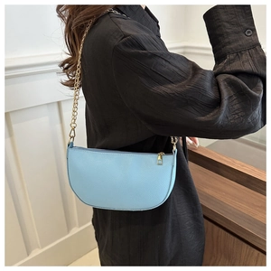 Nahaufnahme der hellblauen sichelförmigen Ledertasche mit eleganter goldener Kette