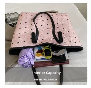 Interior view of pink bow tote bag showing capacity for umbrella, phone, and notebooks