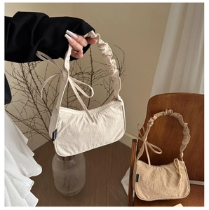 Detail of pleated shoulder bags in beige and khaki with soft cotton-linen texture