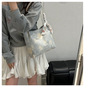 Floral canvas tote bag with woven handles and silk scarf detail shown in a mirror selfie