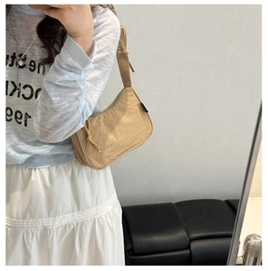 Khaki nylon pleated shoulder bag shown on model in a casual daily mirror selfie shot
