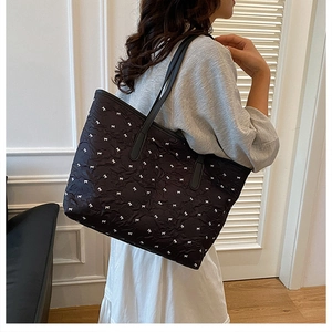 Détail de la texture plissée et des motifs de nœuds blancs délicats sur le sac fourre-tout