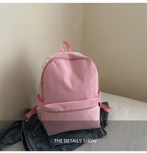 Detailed view of pink backpack with PINK text, front zipper pocket and side mesh storage