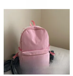 Detailed view of pink backpack with PINK text, front zipper pocket and side mesh storage