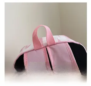 Close-up of pink and black nylon backpack featuring breathable mesh and reinforced stitching