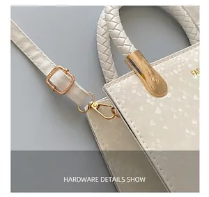 Details der weißen Handtasche mit Schlangenhaut-Prägung, Goldbeschlägen und geflochtenem Griff