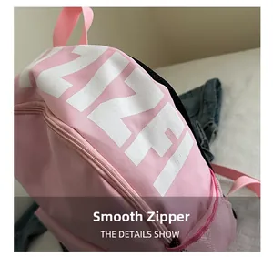 Close-up of pink nylon backpack showing smooth zipper detail and white lettering
