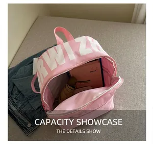 Pink canvas backpack interior showing large capacity with notebook and umbrella