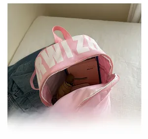 Pink canvas backpack interior showing large capacity with notebook and umbrella