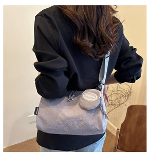 Dettaglio della borsa a tracolla in nylon grigio-viola con portamonete tondo rimovibile