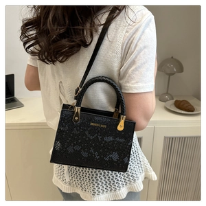 Elegant black snakeskin pattern handbag styled over the shoulder for a chic daily look