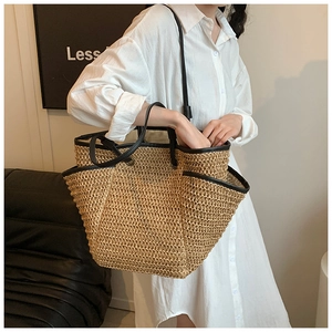 Detail of hand-woven straw tote bag with leather straps and side pockets for seaside travel