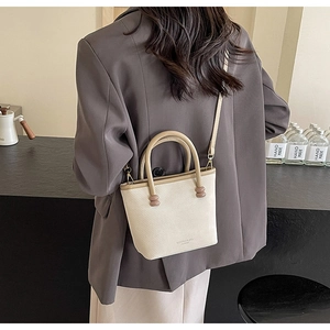Détail du sac bandoulière crème avec cuir texturé et poignées à perles décoratives