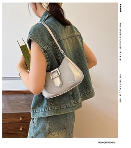 Silver crescent underarm bag with metal buckle shown on model with casual denim outfit