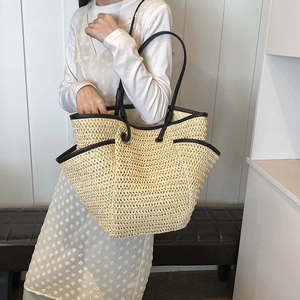 Large straw tote bag with black leather straps for summer beach holidays and shopping