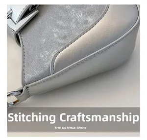 Detailed view of silver crescent bag showing precise stitching and metallic chain buckle