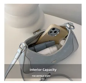 Overhead view showing the spacious interior of the grey crescent bag with daily essentials