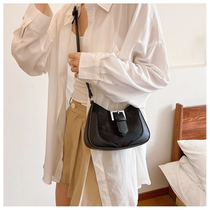 Detail of black crescent shoulder bag with glossy leather and silver square buckle