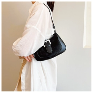 Detail of minimalist black underarm bag with fur texture and silver buckle accents