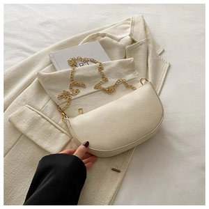 Close-up of litchi texture cream dumpling bag with elegant gold chain shoulder strap