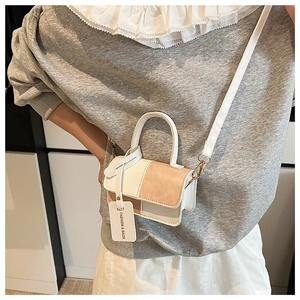 Detail of mini patchwork crossbody bag in beige and orange pink with fashion tag