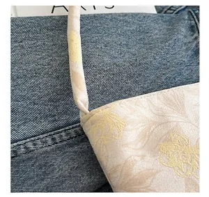 Detailed macro shot of floral fabric tote bag handle and refined stitching texture