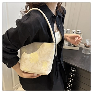 Detailed shot of a vintage canvas tote bag with yellow floral prints on cream white base