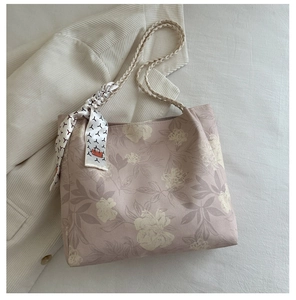 Gros plan détaillé du sac cabas floral avec anses tressées et foulard en soie