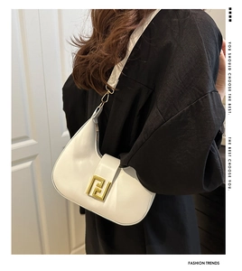 Detailed view of the creamy white crescent bag with golden double F metal buckle on model