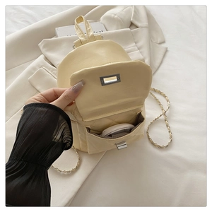Quilted beige mini backpack detail showing interior storage and gold chain strap
