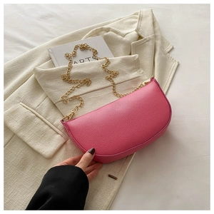 Close-up of pink crescent saddle bag with litchi grain texture and gold chain strap