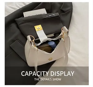 Interior capacity display of white half-moon saddle bag showing personal items and gold hardware