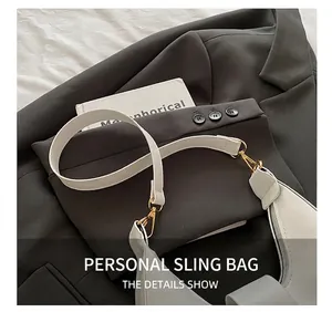 Detailed shot of beige leather crescent shoulder bag with elegant gold metal buckles