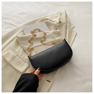 Detail of black lychee leather crescent bag with chunky gold chain strap and zipper