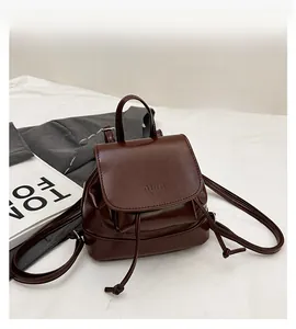 Detailed view of the dark brown leather mini backpack with drawstring and flap closure