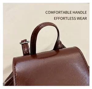 Detail of a dark brown PU leather handbag featuring a smooth curved handle and textured flap