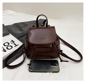 Mini brown faux leather backpack with drawstring and phone for size comparison