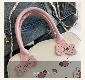 Detalle del asa de cuero rosa y el lazo decorativo en el bolso de dibujos animados blanco