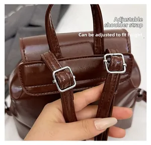 Detail of adjustable shoulder straps with silver buckles on a dark brown backpack