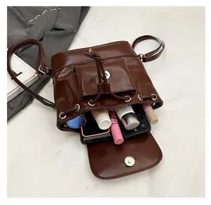Top view of open dark brown bucket bag showing spacious interior with beauty essentials