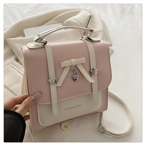 Detail of pink and beige mini handbag with decorative bow and fashion text