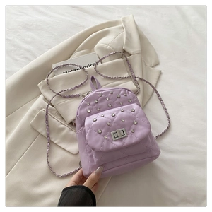 Détail du mini sac à dos matelassé lilas avec clous en strass et fermoir tournant