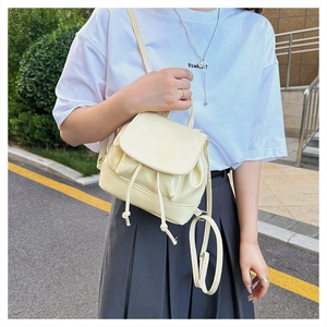 Detail view of mini cream yellow PU leather backpack with adjustable straps and flap
