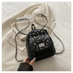 Gros plan du mini sac à dos matelassé noir avec strass et bandoulière en chaîne argent